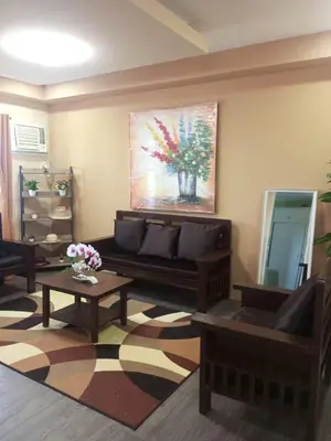 a living room with a couch and a painting on the wall at Urban Zen in Calamba