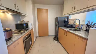 a kitchen with a sink and a refrigerator at EG Private House -BGC UPTOWN in Manila