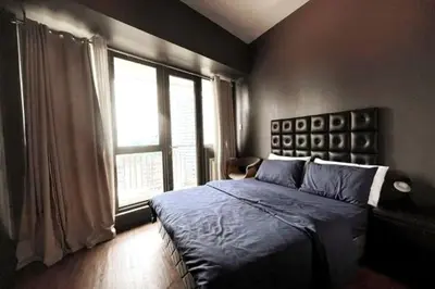 a bedroom with a bed and a large window at 1BR with Balcony KL Tower, Greenbelt near AIM in Manila