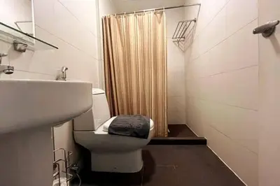 a bathroom with a toilet and a sink and a shower at 1BR with Balcony KL Tower, Greenbelt near AIM in Manila