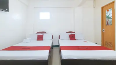 two beds in a room with white and red sheets at RedDoorz @ Western Bicutan Transients Inn in Manila
