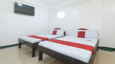 two beds in a room with a tv on the wall at RedDoorz @ Western Bicutan Transients Inn in Manila