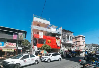 two cars parked on a city street with buildings at RedDoorz @ Western Bicutan Transients Inn in Manila