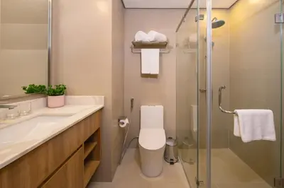 a bathroom with a toilet and a glass shower at Somerset Valero Makati in Manila