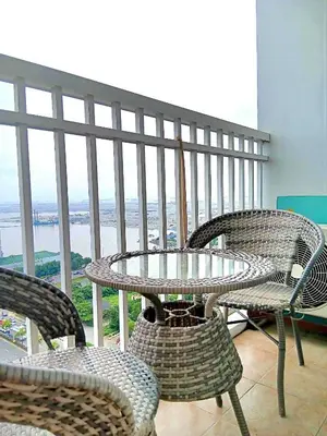 a table and chairs on a balcony with a view at New York Suite - by GUEST RESERVATION'S MANILA in Manila