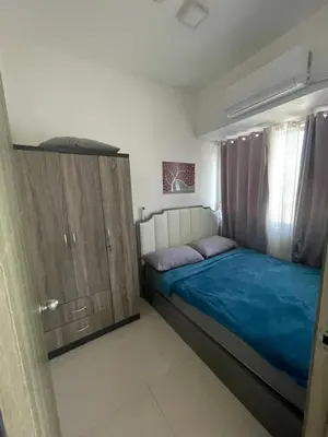 a bedroom with a bed and a wooden cabinet at Fame Residences 1 bedroom near MRT, Shaw, Megamall, Shangrila, Ortigas 1401 in Manila
