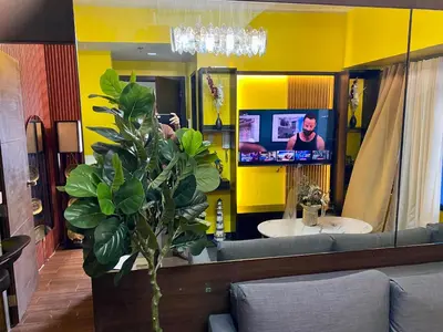 a bathroom with a yellow wall with a mirror and a tv at Laugh and Lounge 2 Bedroom Luxury Condo Air residence Makati in Manila