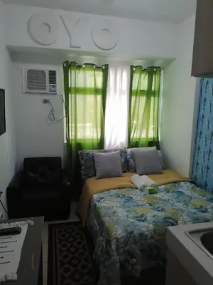 a small bedroom with a bed and a chair at pierecondotel in Manila