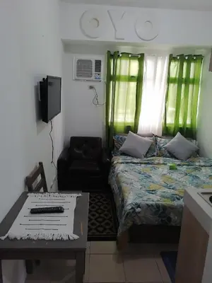a bedroom with a bed and a table with a keyboard at pierecondotel in Manila