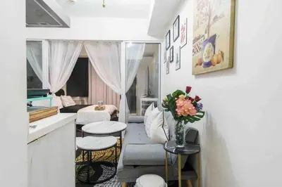 a living room with a couch and a table at Azure skyview 1BR netflix karaoke ps3 Airport in Manila