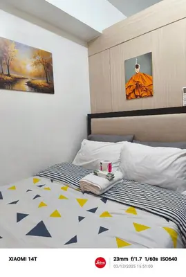 a bedroom with a bed with a yellow and blue comforter at Condo UNIT-SM JAZZ RESIDENCES in Manila