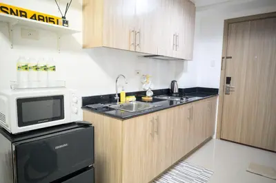 a small kitchen with a sink and a microwave at Shore Residences Tower C, Pasay near SM MOA, please text or call us ASAP once booked for the guest authorization form in Manila
