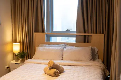 a teddy bear laying on a bed in a bedroom at BGC 3BR Uptown Parksuites with bathtub 16 in Manila