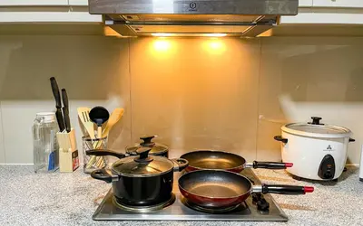 two pots and pans sitting on a stove top at BGC 2BR Uptown Parksuites with PS4 43 in Manila