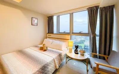 a bedroom with a bed and a table and a window at BGC 2BR Uptown Parksuites with PS4 43 in Manila