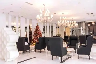 a room with chairs and a christmas tree in it at Azure 1BR citylights with netlfix near airport in Manila