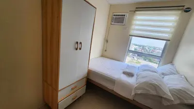 a small bedroom with a bed and a window at URBAN DECA Homes SM EAST Pasig in Manila