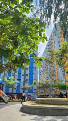 a person riding a skateboard in front of a tall building at URBAN DECA Homes SM EAST Pasig in Manila