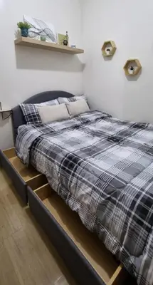a bedroom with a bed with a black and grey blanket at Bicutan Urban Haven in Manila
