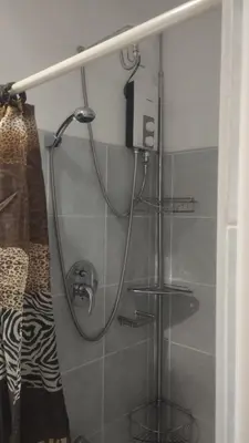 a shower with a hose attached to a wall at S Residences in Manila