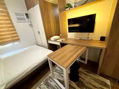 a bedroom with a desk with a bed and a television at Casa Del Hasmin in Puting Kahoy