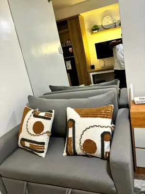 a couch in a room with pillows on it at Casa Del Hasmin in Puting Kahoy