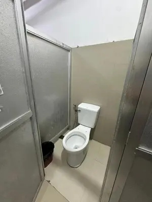 a small bathroom with a toilet in a stall at St John's Pearl Transient House in Manila