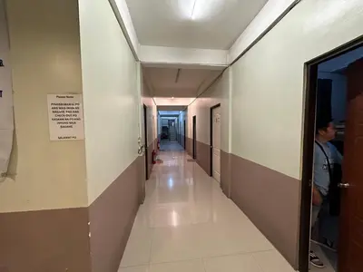 a hallway in a hospital with a person walking down at St John's Pearl Transient House in Manila