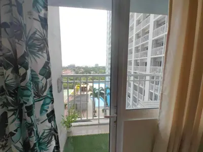 an open door to a balcony with a view of a building at Condo Near MOA, NAIA, PICC, & CCP that is comfy with a view! in Manila
