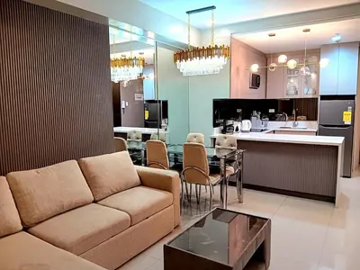 a living room with a couch and a dining room at California Suite - by GUEST RESERVATION'S MANILA in Manila
