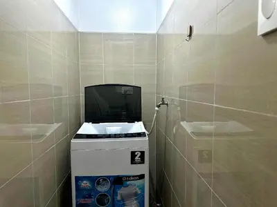 a washing machine in a bathroom with a tiled wall at California Suite - by GUEST RESERVATION'S MANILA in Manila