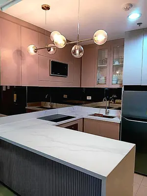 a large kitchen with a white counter top and appliances at California Suite - by GUEST RESERVATION'S MANILA in Manila