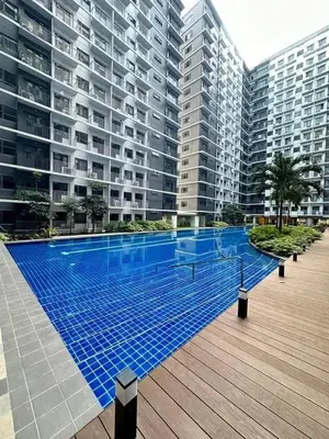 a swimming pool in front of a large building at One bedroom with Balcony-M&M City Comfort in Manila