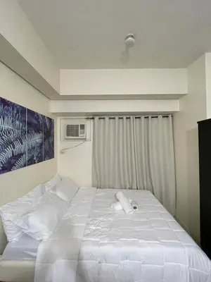 a bedroom with a white bed with two towels on it at Mountain View at Beacon Tower in Manila