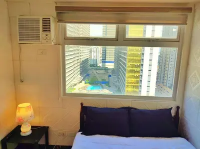 a bedroom with a window with a view of a city at Urban Deca EDSA Budget Place w/ Unli Wi-Fi Netflix in Manila
