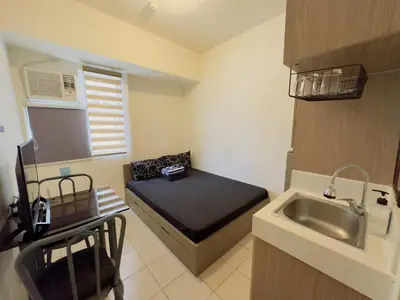 a small room with a bed and a sink at Urban Deca EDSA Staycation w/Unli Wi-Fi & Netflix in Manila