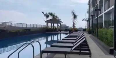 a row of benches next to a swimming pool at COAST RESIDENCES in Manila