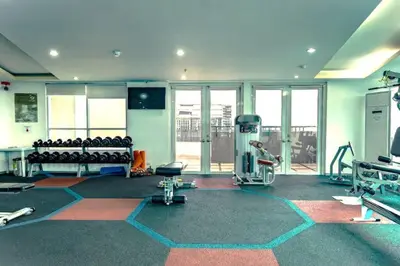 a gym with a lot of equipment in a room at BGC Beautiful Large 1 Bedroom Condo Sleeps 3 Adults in Manila