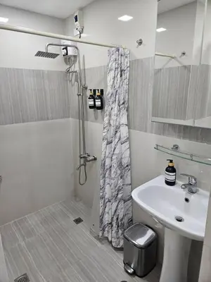 a bathroom with a shower curtain and a sink at BGC Beautiful Large 1 Bedroom Condo Sleeps 3 Adults in Manila