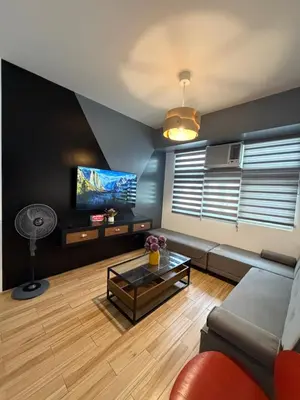 a living room with a couch and a tv at Holland Park Condominium in Jalang