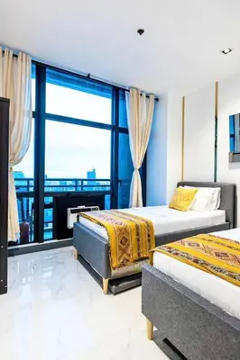 a bedroom with two beds and a large window at Kaiyana Apartments in Manila
