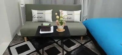 a living room with a couch and a table with a laptop at Ilustrata Residences Condominium in Manila