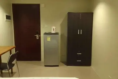 a room with a refrigerator and a wooden cabinet at Spacious Studio Apartment B304 in Manila