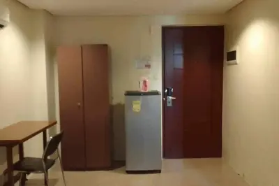 a room with a refrigerator and a table and a door at Spacious Studio Apartment B306 in Manila