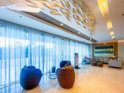 a lobby with large windows and furniture in a building at Amazing Condo Unit Shore 3 - walking distance to MOA - Pasay - 2 Beds - with 1 extra bed in Manila