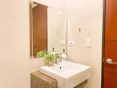 a bathroom with a white sink and a mirror at BGC's Best Condo Near Uptown Mall #oursw15o in Manila
