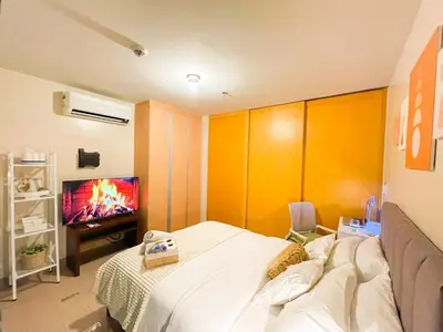 a bedroom with a bed and a tv in it at BGC's Best Condo Near Uptown Mall #oursw15o in Manila