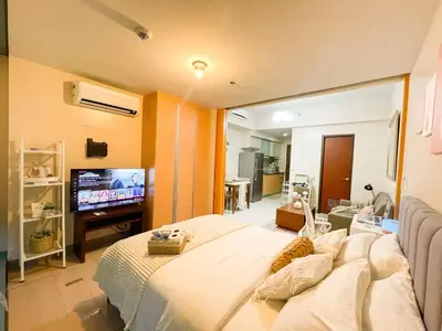 a bedroom with a large bed and a television at BGC's Best Condo Near Uptown Mall #oursw15o in Manila