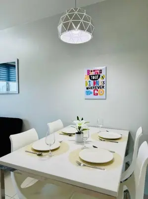 a white dining room table with white chairs and a light fixture at Cozy Minimalist 2BR Condo at Princeton QC near Rob Magnolia in Manila