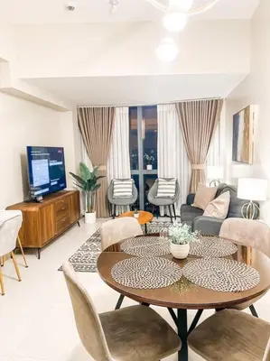 a living room with a table and a couch at New Modern Luxurious 2Bedroom in Eastwood in Manila